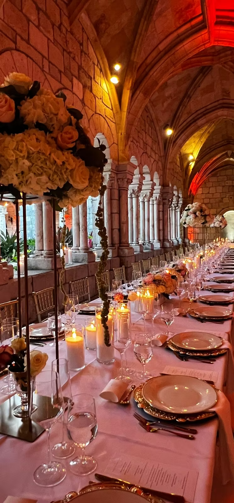 A candlelit wedding reception table in a historic arched venue